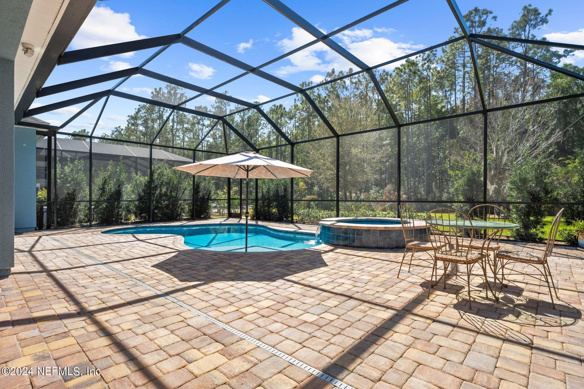 206 Medio Drive St. Augustine, FL 32095 - Photo 27 of 57 a view of patio with a table and chairs under an umbrella