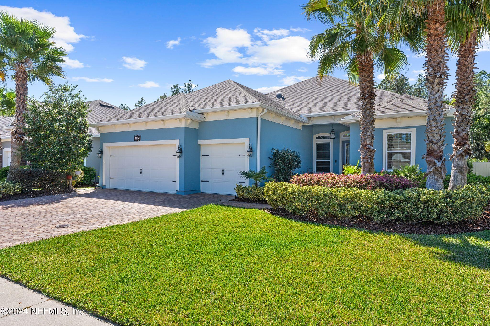 206 Medio Drive St. Augustine, FL 32095 - Photo 3 of 57 a view of a white house next to a yard and palm trees