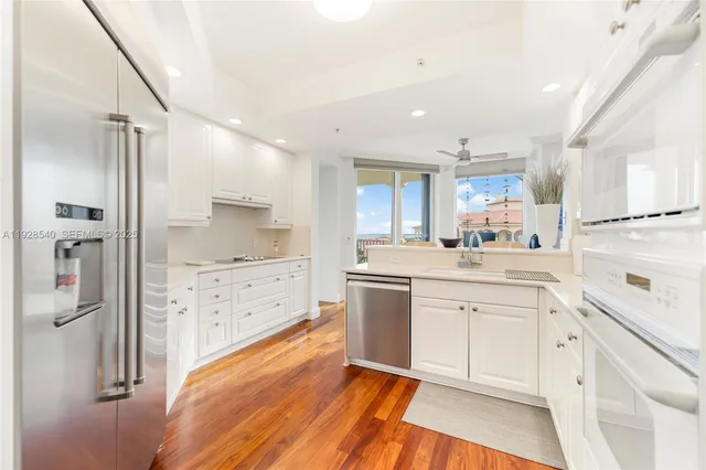 a kitchen with white cabinets and refrigerator