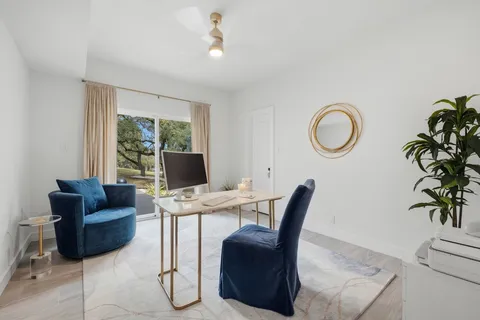 a workspace with furniture and a large window