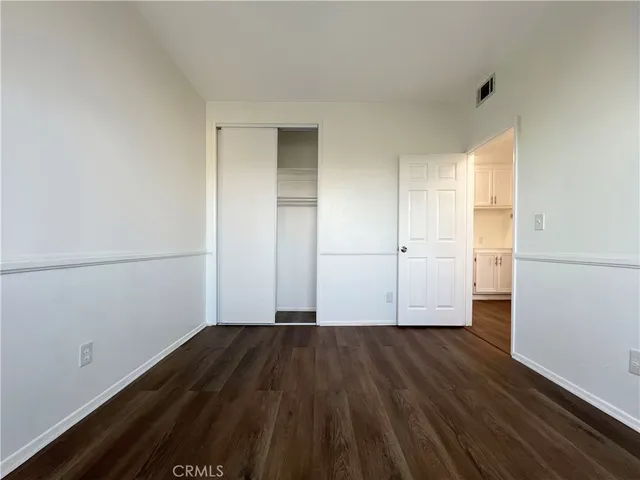 an empty room with wooden floor and white walls