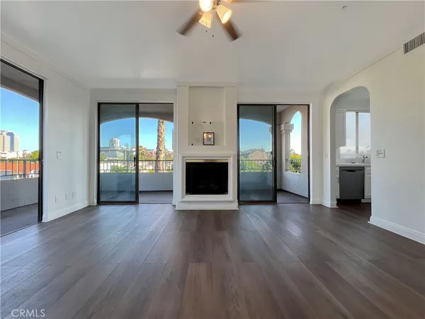 an empty room with wooden floor and a fireplace