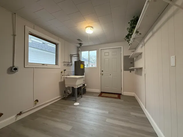 a view of a hallway to a livingroom with furniture and a window