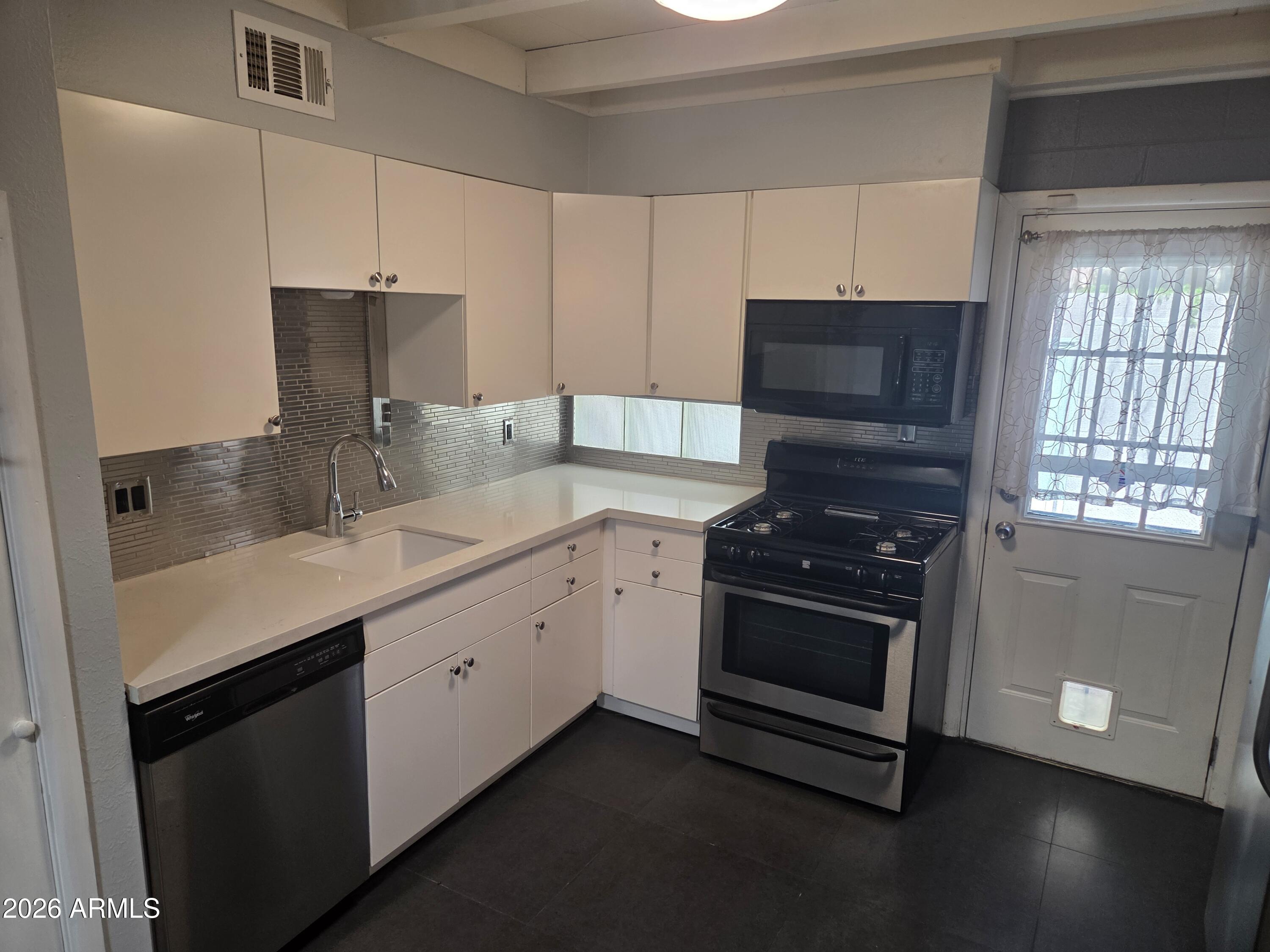 1101 East Bethany Home Road, Unit 7 Phoenix, AZ 85014 - Photo 6 of 14 a kitchen with granite countertop a sink stainless steel appliances and cabinets