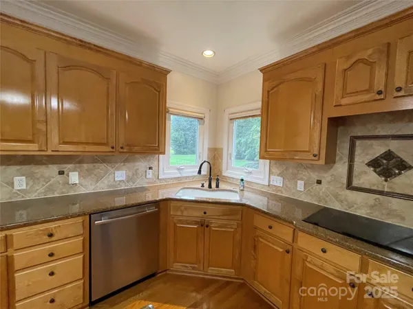 a kitchen with stainless steel appliances granite countertop a refrigerator a sink dishwasher a stove with wooden cabinets and floor