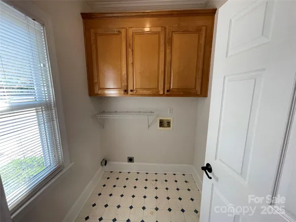 an empty room with wooden floor chandelier fan and windows