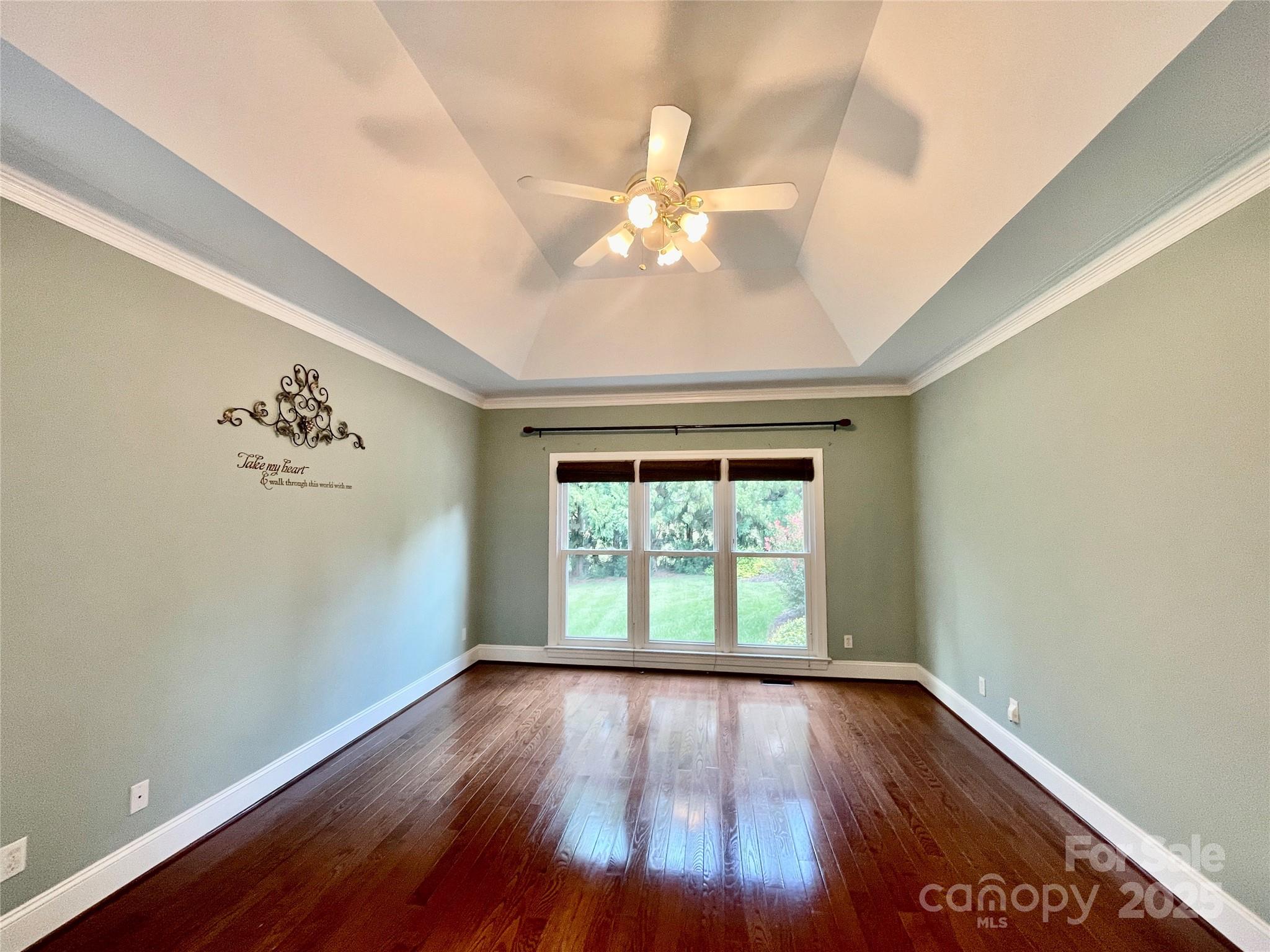 103 Berea Baptist Church Road Stanfield, NC 28163 - Photo 26 of 46 an empty room with wooden floor chandelier fan and windows