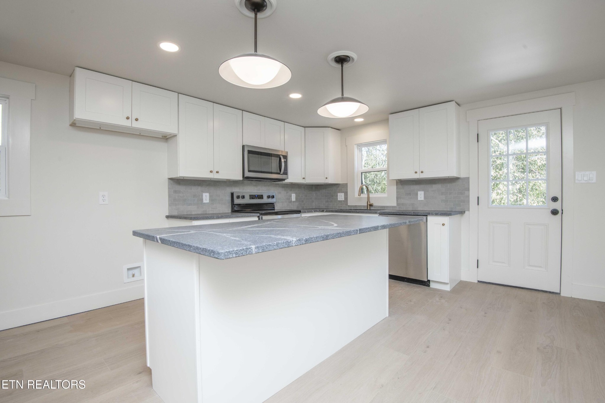 6223 Babelay Road Knoxville, TN 37924 - Photo 24 of 53 a kitchen with kitchen island granite countertop stainless steel appliances a sink a stove a microwave a center island and cabinets