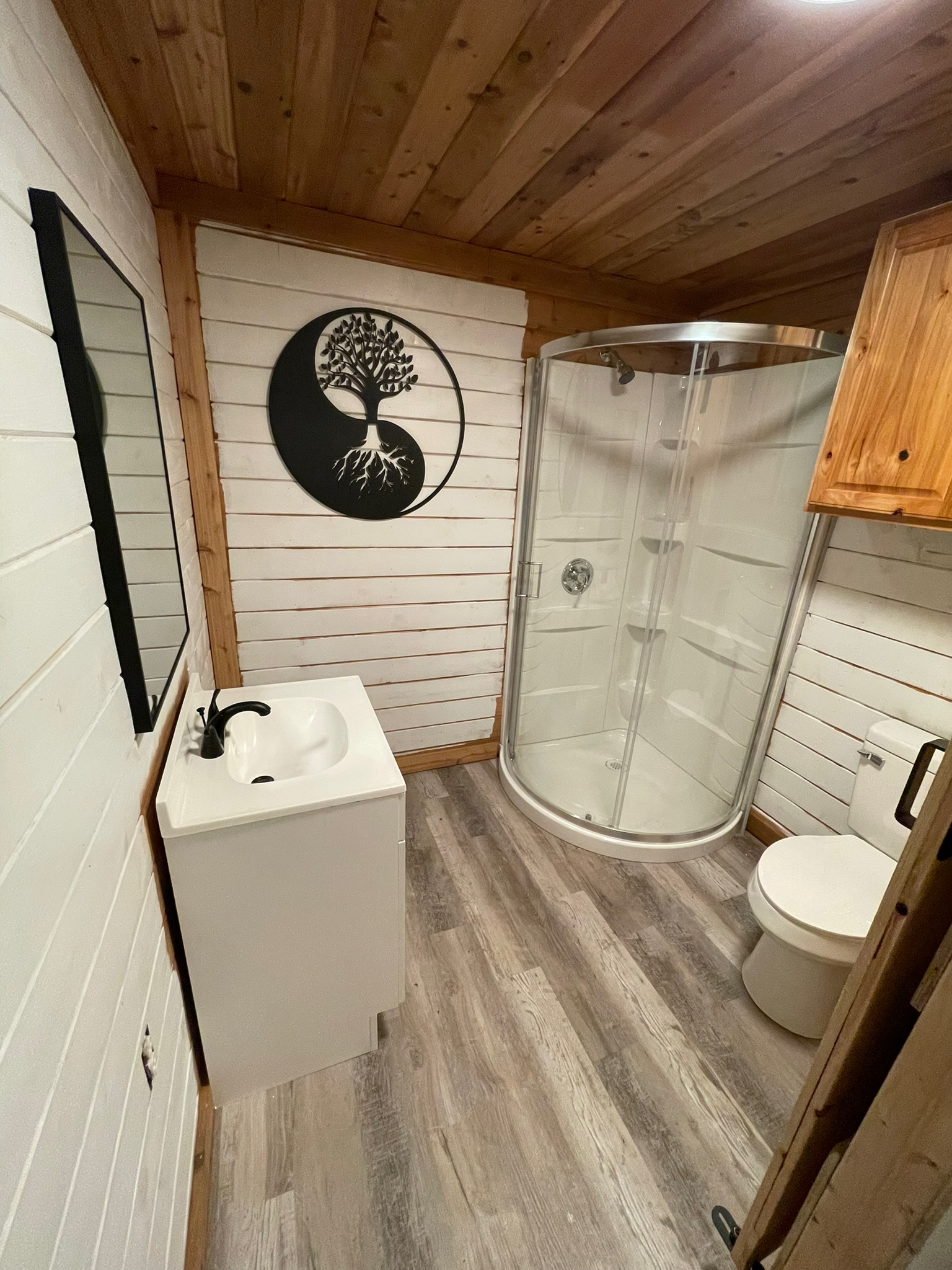 1512 River Grove Road, Unit A Kingsbury, TX 78638 - Photo 26 of 35 Bathroom with wooden walls, a shower stall, vanity, light wood-style flooring, and wood ceiling