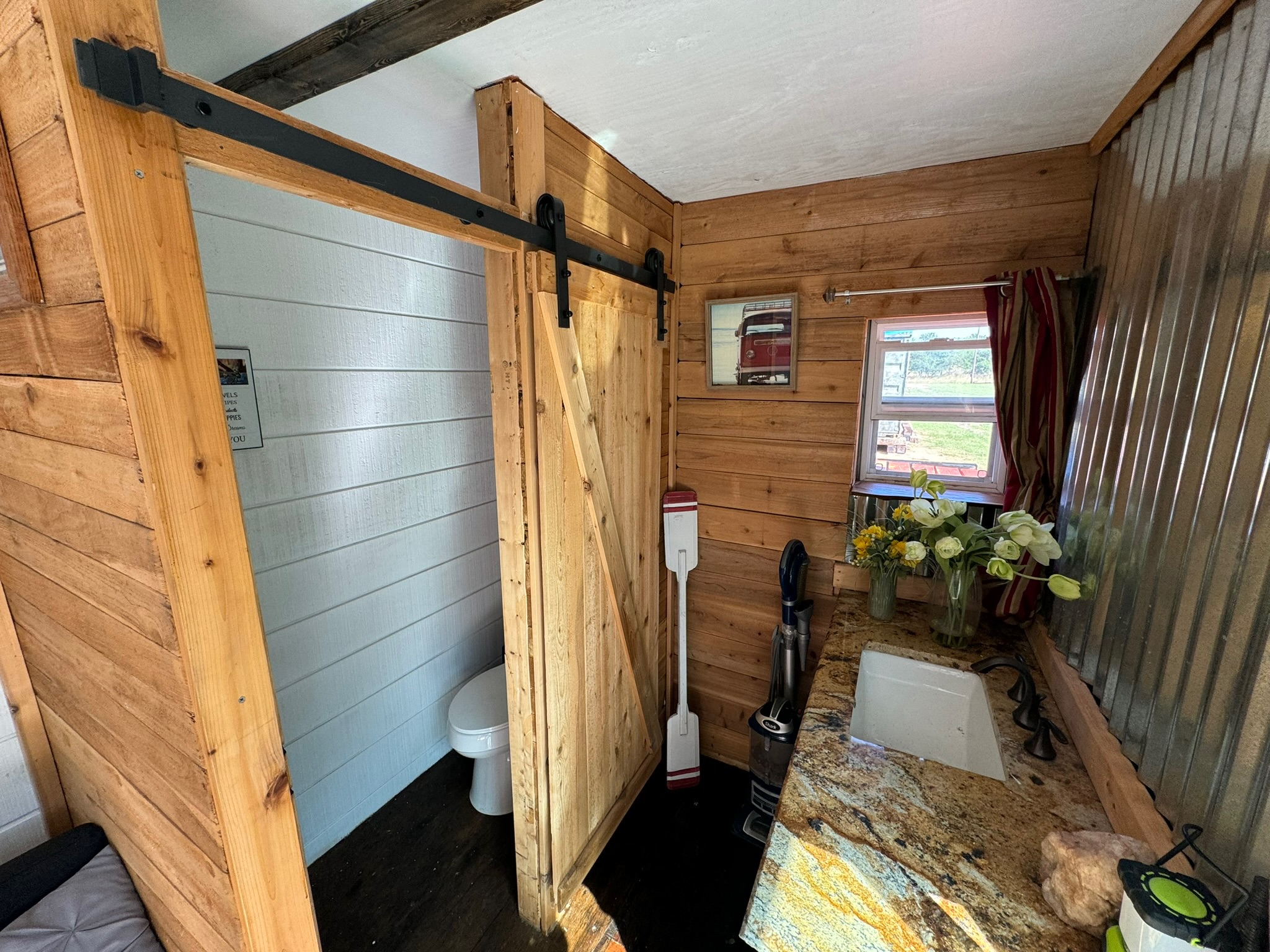 1512 River Grove Road, Unit A Kingsbury, TX 78638 - Photo 29 of 35 Bathroom with wooden walls, vanity, and dark wood-style flooring