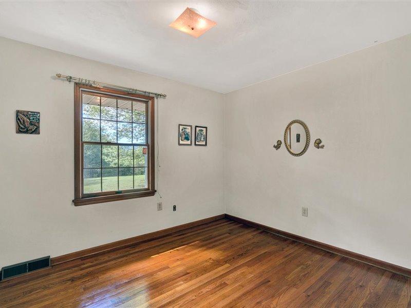 249 Zimmerman Road Blue Ridge, VA 24064 - Photo 17 of 33 an empty room with wooden floor and windows