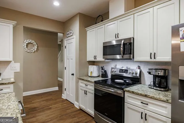 a kitchen with stainless steel appliances granite countertop a stove and a refrigerator