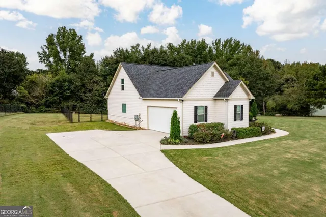 an aerial view of a house with a yard and lake view