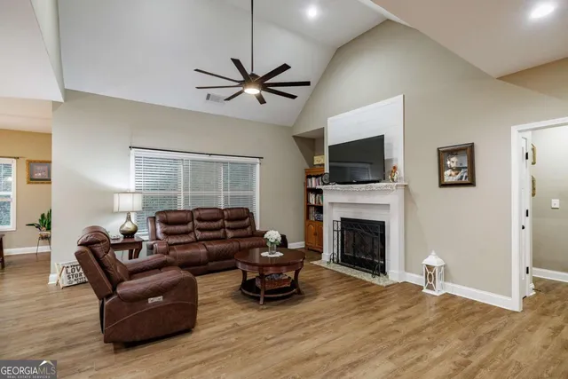 a living room with furniture a fireplace and a flat screen tv