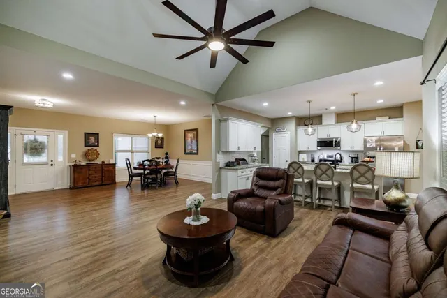 a living room with furniture and a view of kitchen