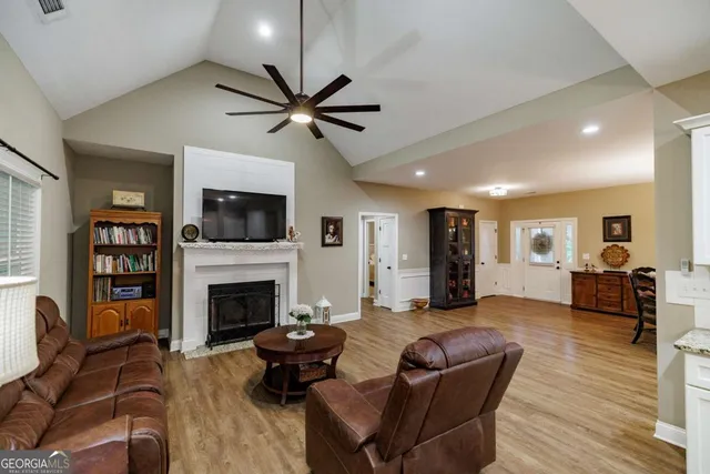 a living room with furniture a fireplace and a flat screen tv
