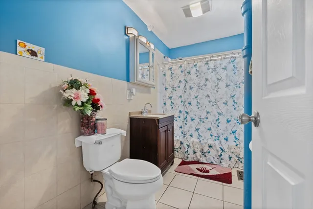 a bathroom with a toilet sink and shower curtain