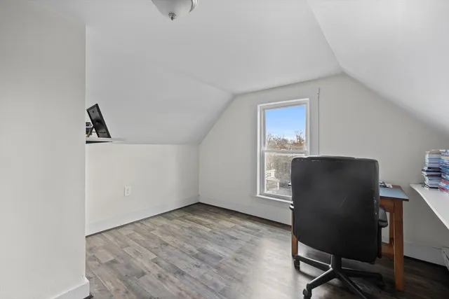 a view of a workspace with furniture and a window