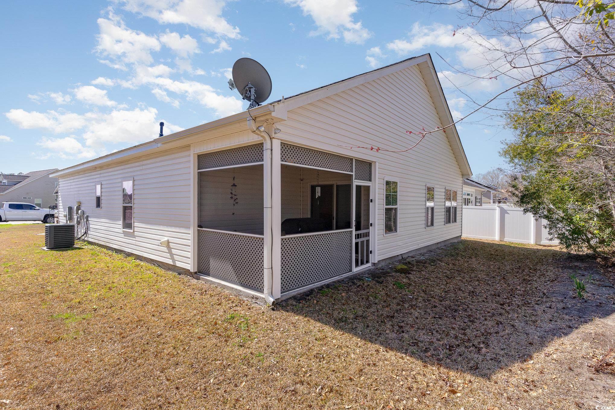 321 Cabo Loop Myrtle Beach, SC 29588 - Photo 22 of 25 Rear view of property featuring a yard, central AC