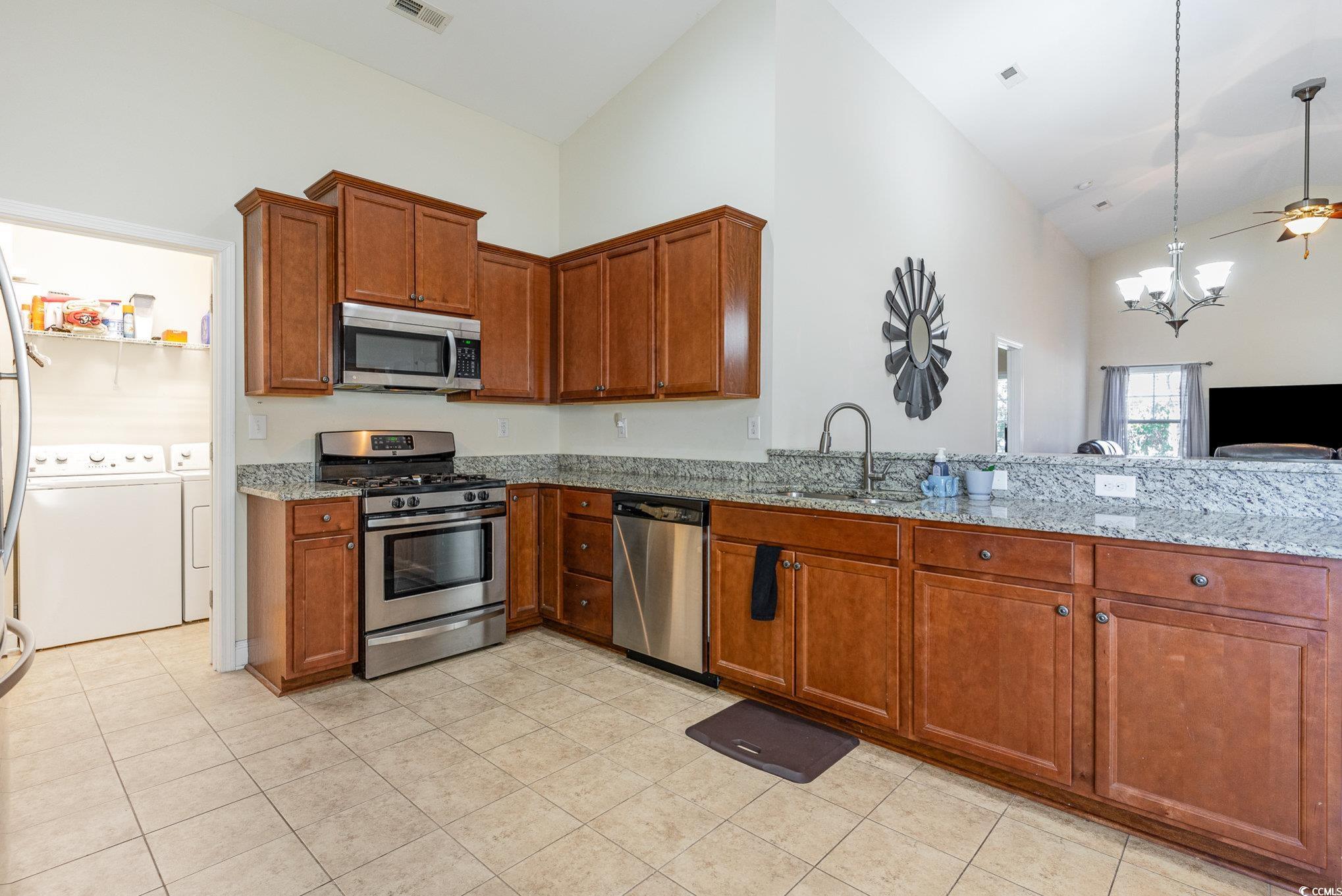 321 Cabo Loop Myrtle Beach, SC 29588 - Photo 6 of 25 Kitchen with light stone counters, brown cabinets,