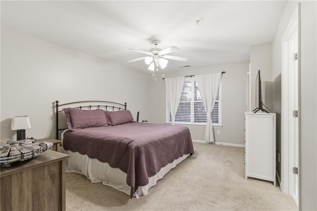 203 River Green Avenue Canton, GA 30114 - Photo 11 of 28 a spacious bedroom with a bed and a chandelier