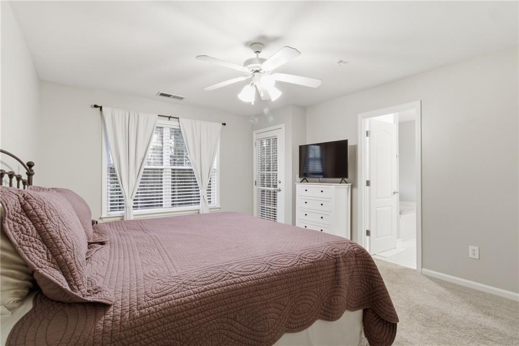 203 River Green Avenue Canton, GA 30114 - Photo 13 of 28 a bedroom with a large bed and a flat screen tv