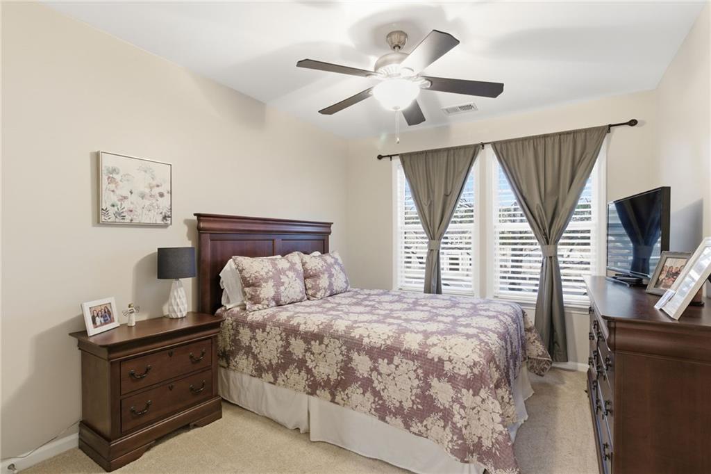 203 River Green Avenue Canton, GA 30114 - Photo 19 of 28 a bedroom with a large bed and a flat tv screen on a dresser