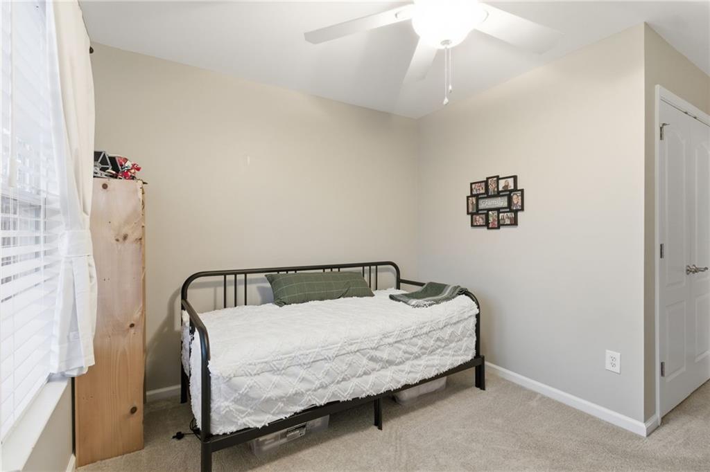 203 River Green Avenue Canton, GA 30114 - Photo 21 of 28 a bedroom with a bed and a chandelier