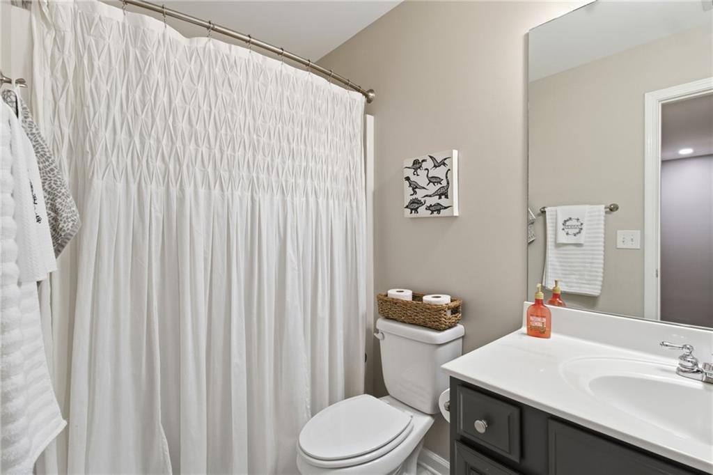203 River Green Avenue Canton, GA 30114 - Photo 22 of 28 a bathroom with a sink a toilet and shower curtain
