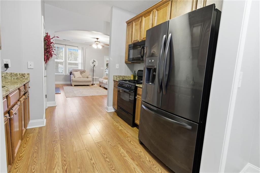 203 River Green Avenue Canton, GA 30114 - Photo 8 of 28 a kitchen with stainless steel appliances a refrigerator stove and wooden floor