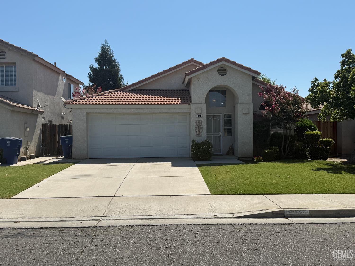 a front view of a house with a garden and trees