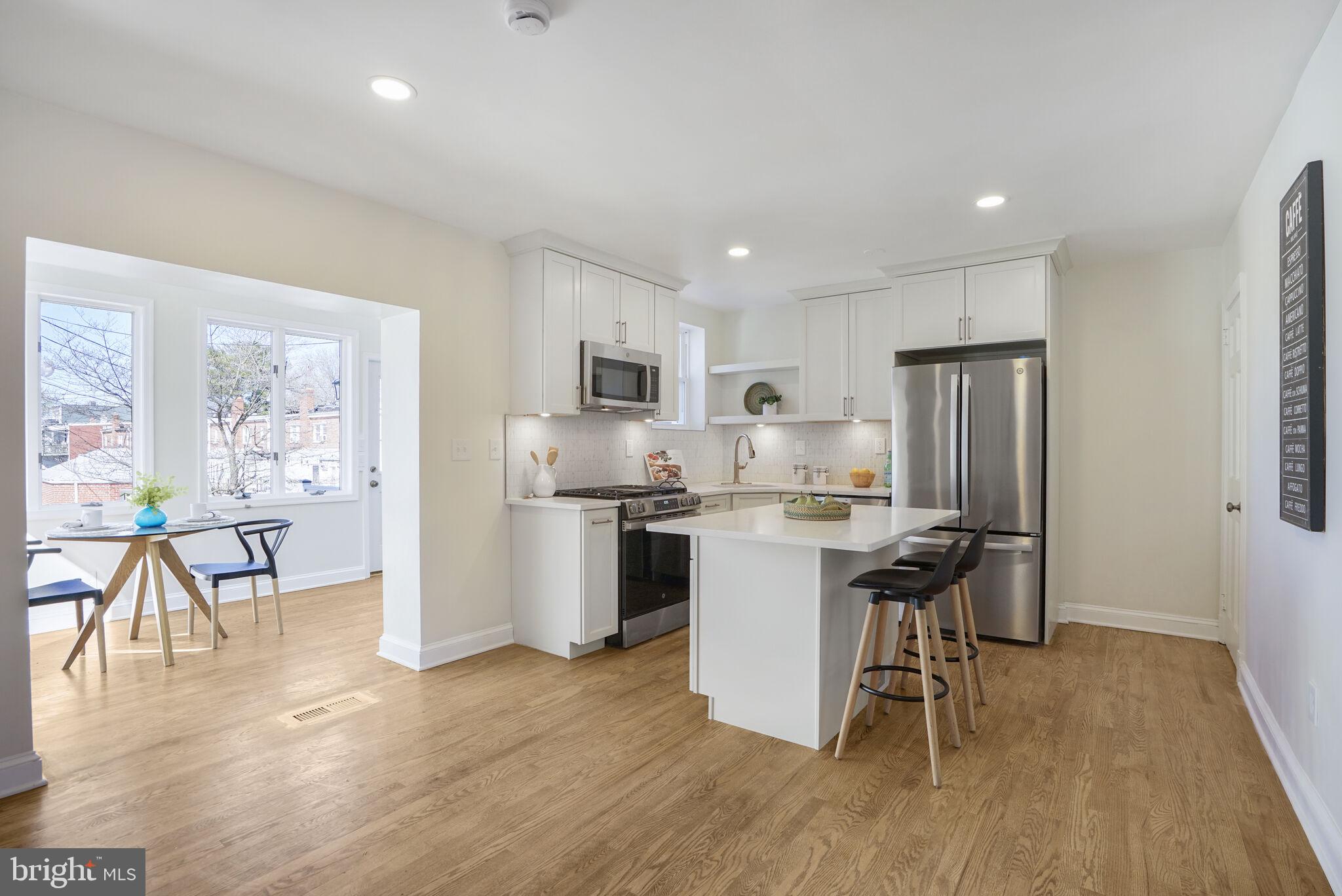 53 Franklin Street Northeast Washington, DC 20002 - Photo 6 of 33 a kitchen with stainless steel appliances granite countertop a refrigerator a sink a stove a dining table and chairs with wooden floor