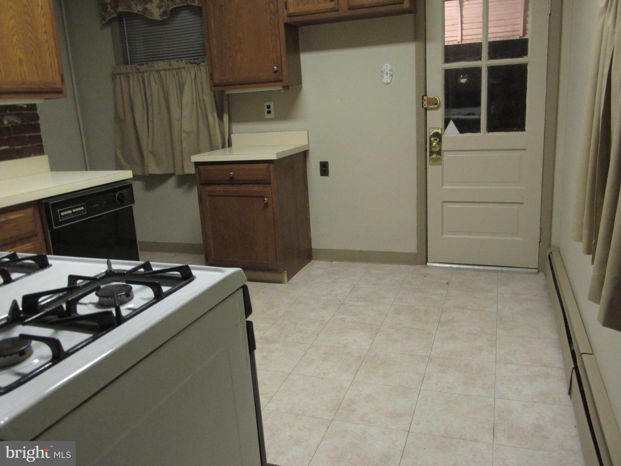 6101 Colgate Street Philadelphia, PA 19111 - Photo 15 of 39 a kitchen with wooden cabinets and stove
