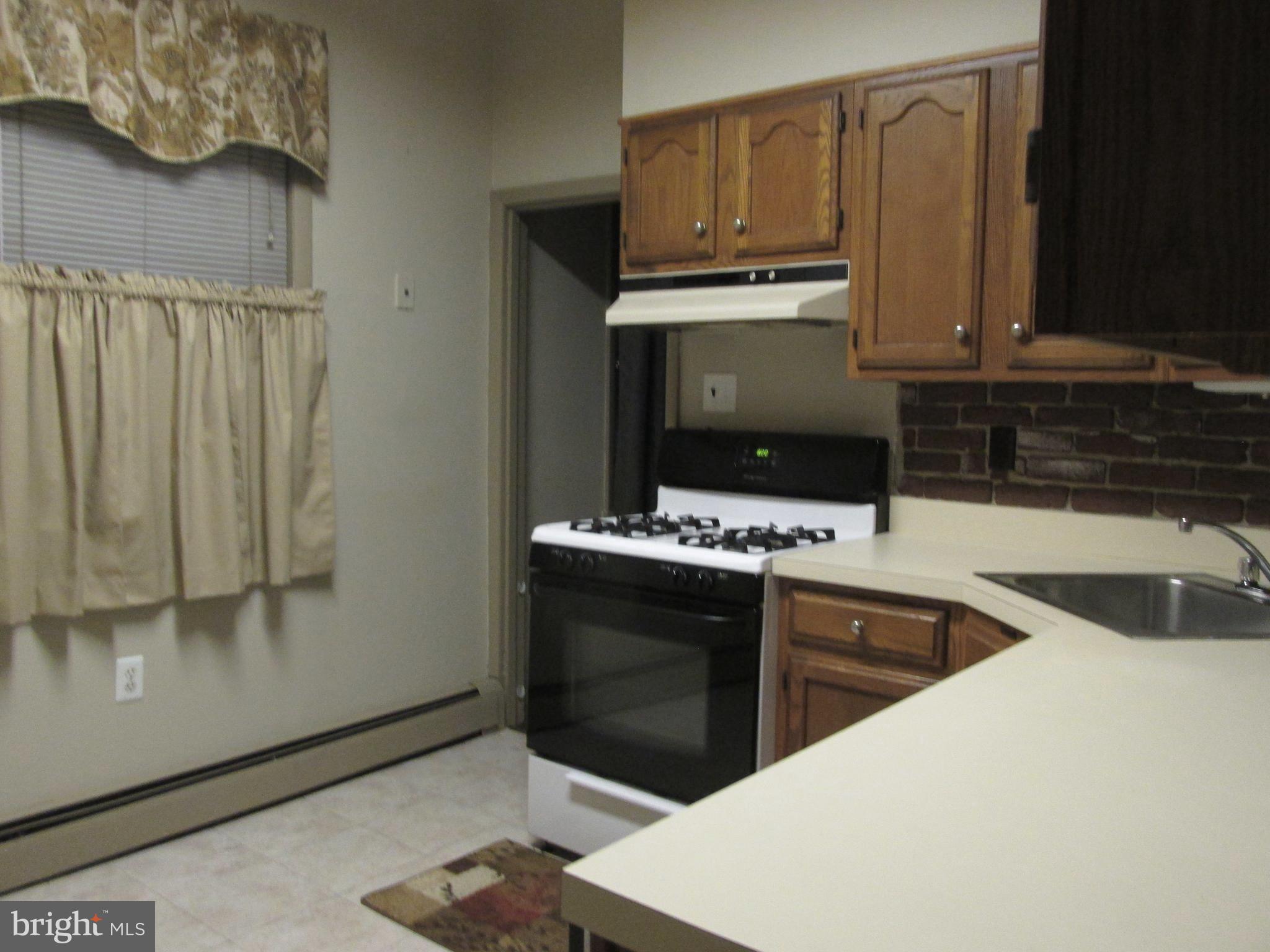 6101 Colgate Street Philadelphia, PA 19111 - Photo 16 of 39 a kitchen with stainless steel appliances a stove a microwave and a sink