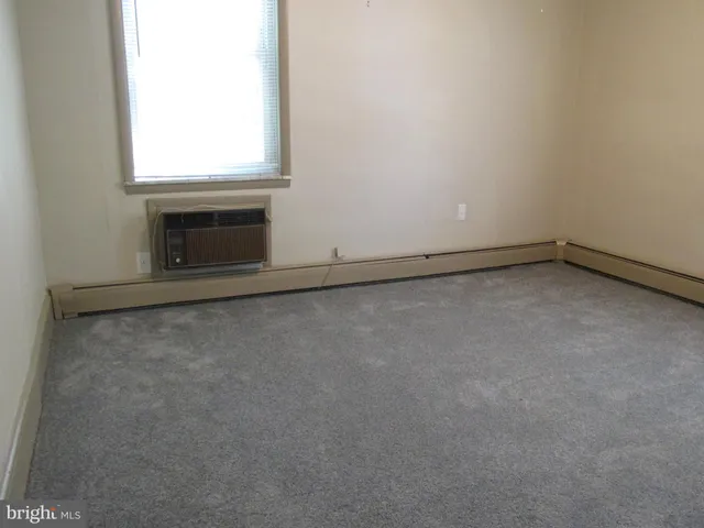 a view of an empty room with a fireplace and a window