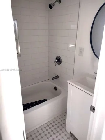 a bathroom with a tub a toilet and a shower