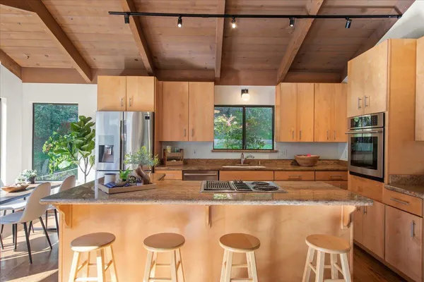 a kitchen with stainless steel appliances granite countertop a sink and a refrigerator