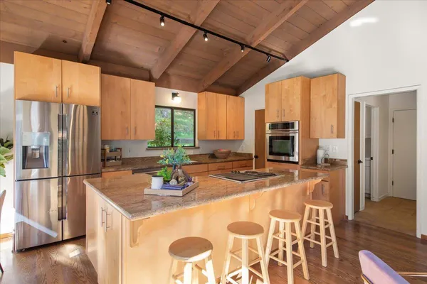 a kitchen with stainless steel appliances granite countertop a sink a stove and refrigerator