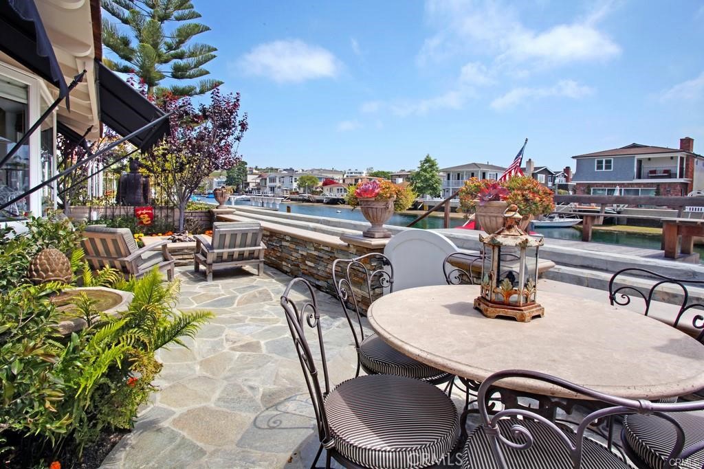 a roof deck with table and chairs plants