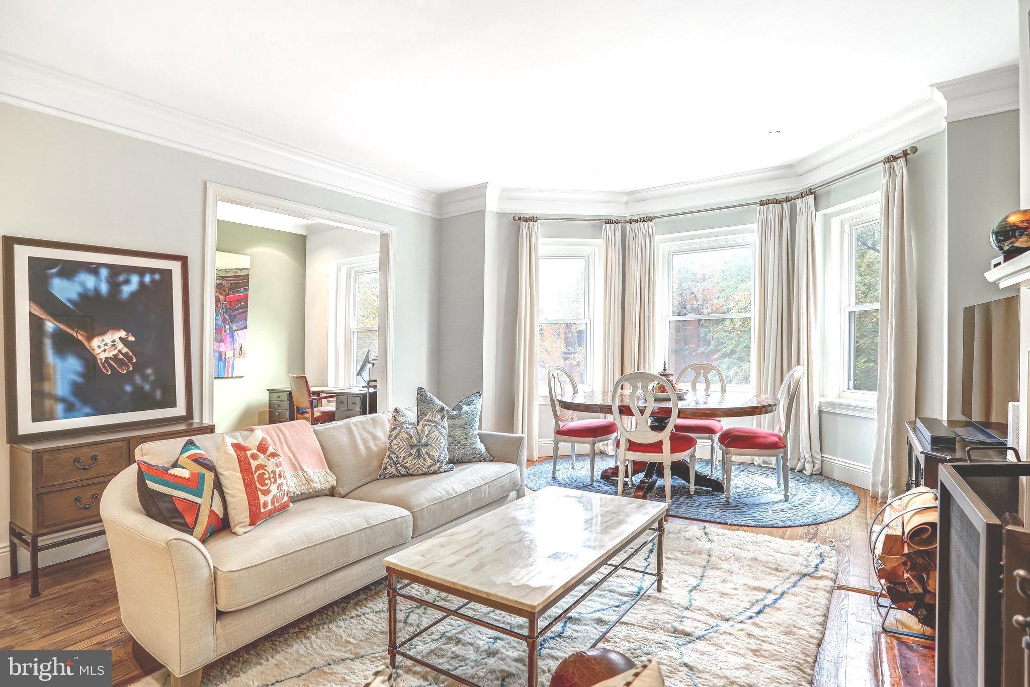 a living room with furniture a flat screen tv and a large window