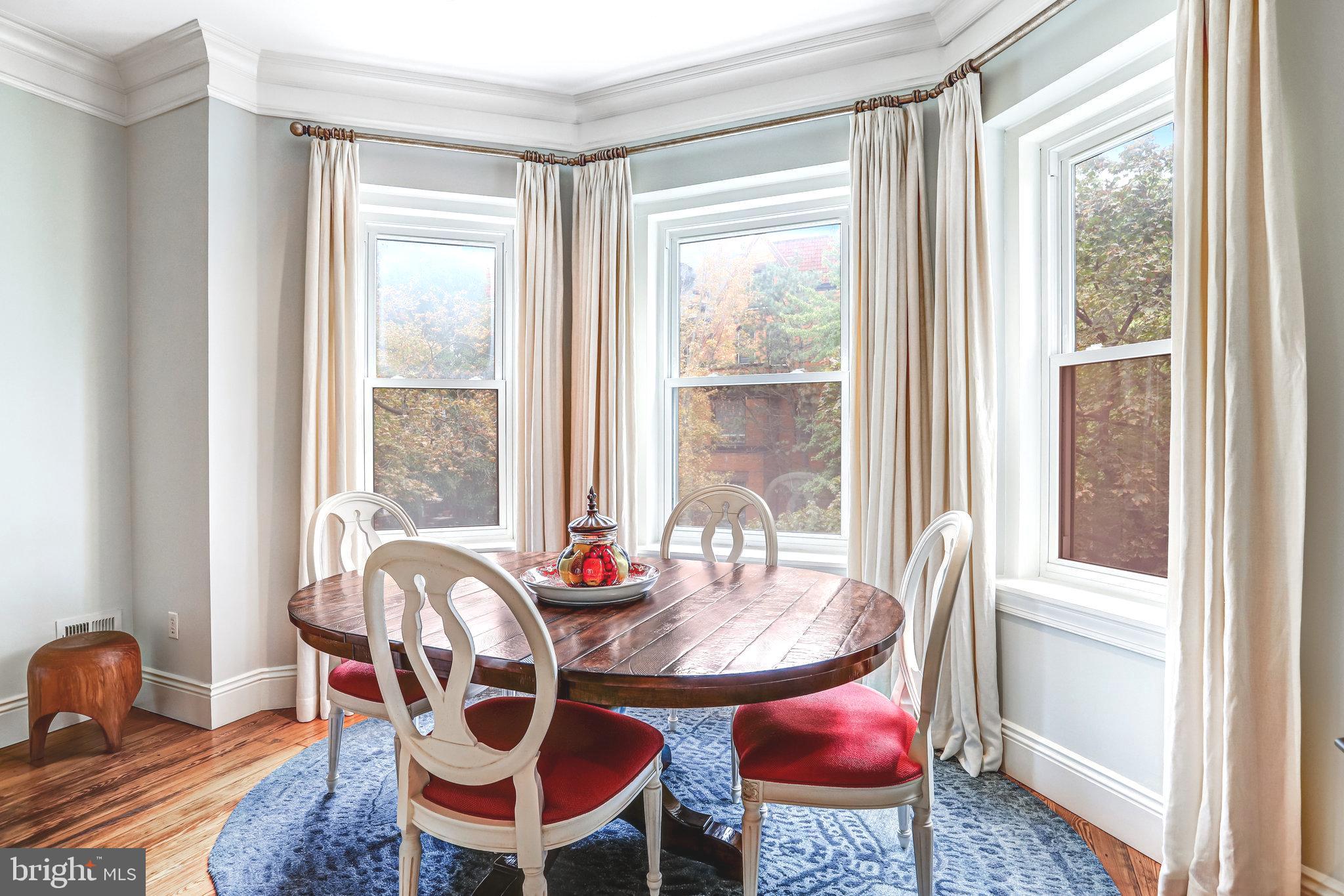 1820 Kalorama Road Northwest, Unit 3 Washington, DC 20009 - Photo 8 of 32 a dining room with furniture a rug a chandelier and wooden floor