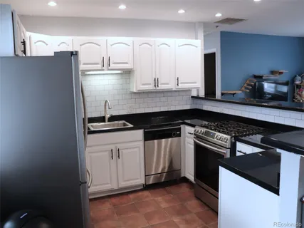 a kitchen with stainless steel appliances granite countertop a sink and a stove