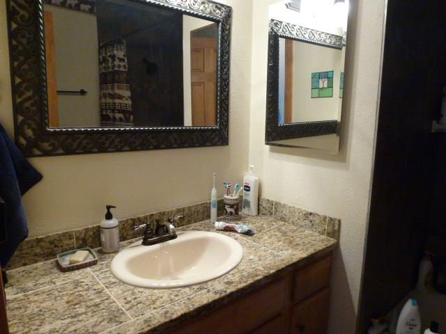 150 Evergreen Road, Unit 205 Dillon, CO 80435 - Photo 2 of 18 a bathroom with a granite countertop sink and a mirror
