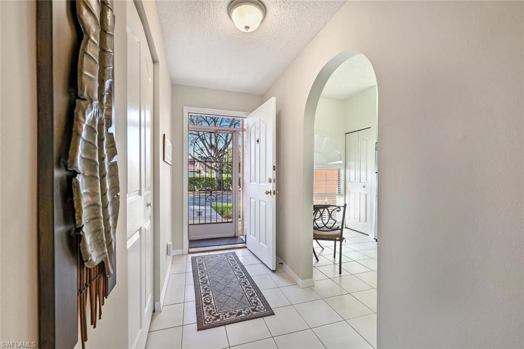 565 Augusta Boulevard, Unit 24 Naples, FL 34113 - Photo 12 of 26 a view of a hallway with wooden floor and a livingroom