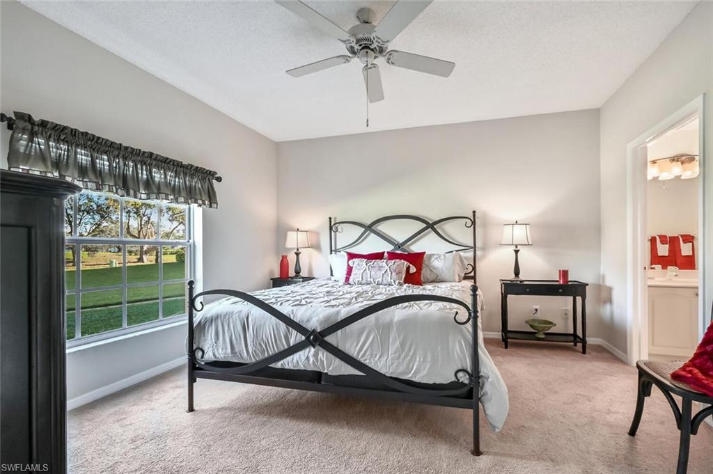 565 Augusta Boulevard, Unit 24 Naples, FL 34113 - Photo 17 of 26 a bedroom with a bed a chandelier and a window