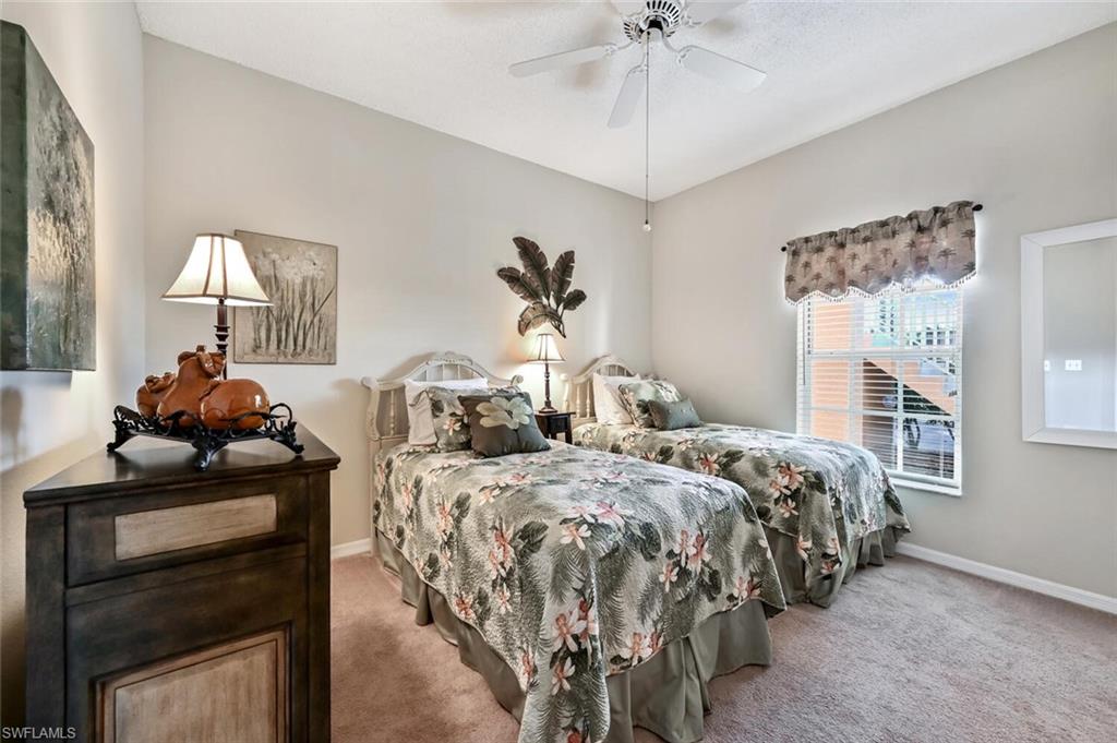 565 Augusta Boulevard, Unit 24 Naples, FL 34113 - Photo 22 of 26 a bedroom with two beds and a chandelier