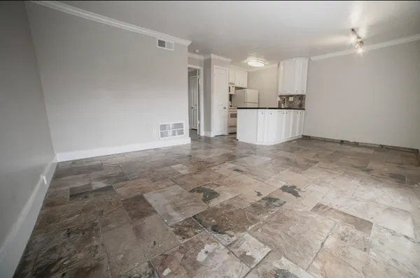 a view of a kitchen with white cabinets and stainless steel appliances