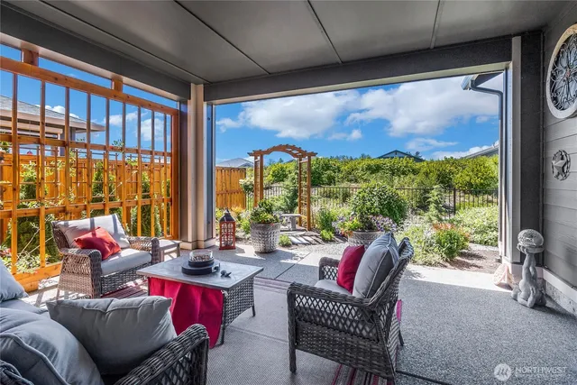 a living room with patio furniture and a floor to ceiling window
