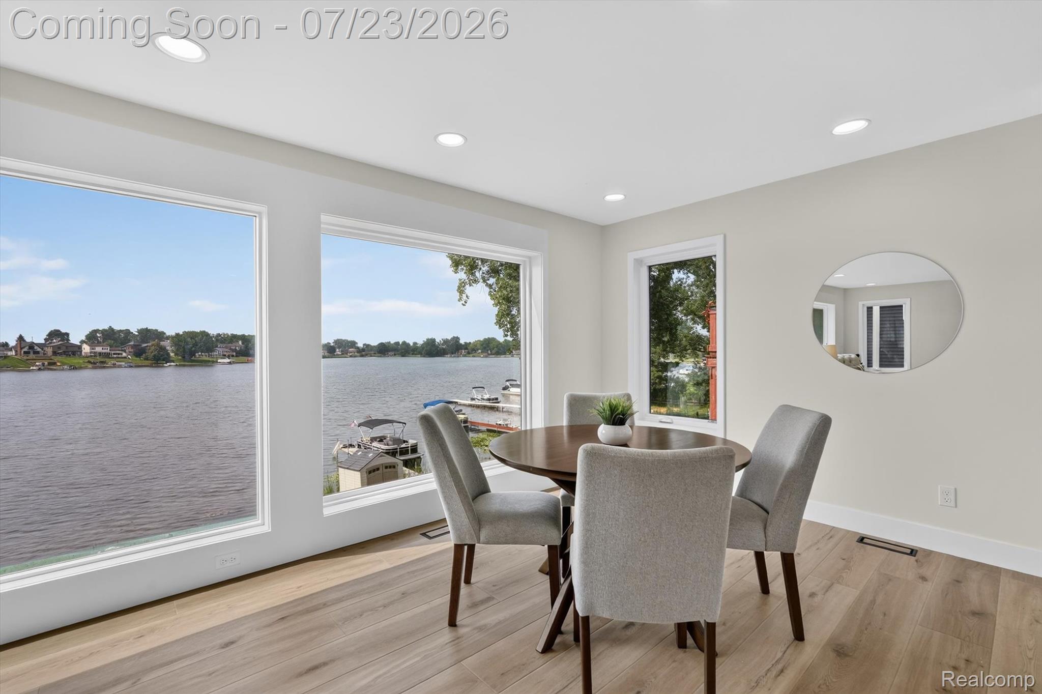 3429 Rolston Road Fenton, MI 48430 - Photo 11 of 62 Spacious room featuring multiple large windows offering significant water frontage, wood-finish flooring, recessed lighting, and a neutral color palette