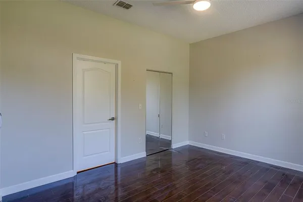 a view of an empty room with wooden floor